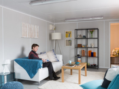 container homes lady reading a book on a sofa